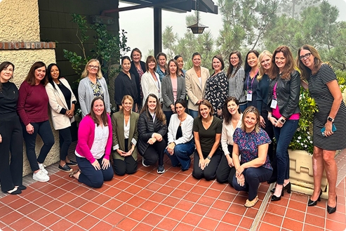 Group of women gathered outdoors on a tiled patio, posing for a photo.