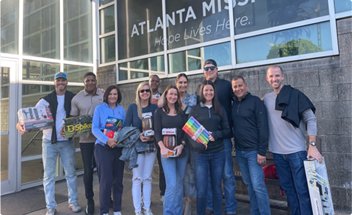 Group of people standing outside Atlanta Mission, holding donated supplies.