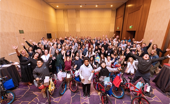 Large group celebration with adults and children on bikes.